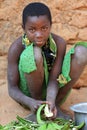 Young woman peels cooking plantains, Tanzania