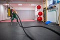 Young woman with perfect body doing crossfit exercises with a rope in the gym. Royalty Free Stock Photo