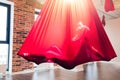 Young woman performig creative dance using red hammock as suspension equipment Royalty Free Stock Photo