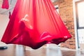 Young woman performig creative dance using red hammock as suspension equipment Royalty Free Stock Photo