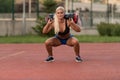 Young Woman Performing Bag Squat Exercise Outdoor Royalty Free Stock Photo