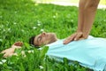 Young woman performing CPR on unconscious man outdoors, closeup. First aid