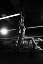 Young woman performing gymnastic exercise on rings Royalty Free Stock Photo