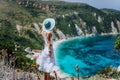Young woman on Petani beach Kefalonia, admiring highly excited picturesque panorama of emerald blue bay of Mediterranean