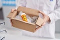 Young woman pharmacist holding package with pills at pharmacy Royalty Free Stock Photo