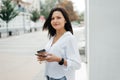 A young woman with a phone and coffee in her hands on the street Royalty Free Stock Photo