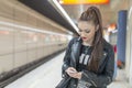 Young woman with phone in subway.