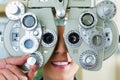 Young woman at phoropter for eye test Royalty Free Stock Photo