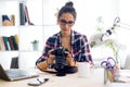 Young woman photographer checking previews on camera in the stud Royalty Free Stock Photo