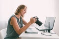 A young woman photographer sitting at his Desk and working with a camera Royalty Free Stock Photo