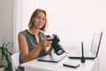 A young woman photographer sitting at his Desk and working with a camera. Copy space Royalty Free Stock Photo