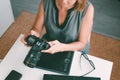 A young woman photographer sitting at his Desk and working with a camera. View from the top. Close up Royalty Free Stock Photo