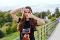 Happy brunette woman making photo with retro camera on city street Royalty Free Stock Photo