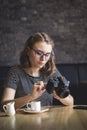 Young woman photographing chimping her photos as she sits relaxing