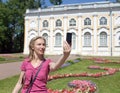 Young woman photographs herself on the cell phone against pavilion Stone hall in Oranienbaum, Petersburg, Russia.