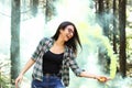 Young woman in a photoshoot holding a smoke bomb yellow in the forest smiling at Costa Rica Royalty Free Stock Photo