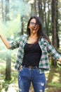 Young woman in a photoshoot raising her hand holding a smoke bomb yellow in the forest smiling at Costa Rica Royalty Free Stock Photo