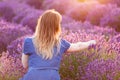 Young woman picking lavender flowers at sunset.