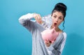 Young woman with a piggy bank with us dollar bills Royalty Free Stock Photo