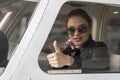 Young Woman Pilot Looking Through The Cockpit Window and Giving Thumb Up Royalty Free Stock Photo