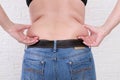 Young woman pinches the fat on the side of her waist to show the flab, overweighted fat body as s result of improper diet Royalty Free Stock Photo