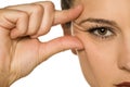 Young woman pinching her eye wrinkles with her fingers