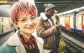 Young woman with pink hair and group of multiracial hipster friends at subway station