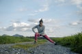 Young woman in pink leggings stretching and warming up before going for a run