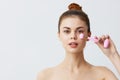 young woman pink quartz roller scraper skin care massage bare shoulders light background