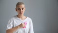 Young woman with pink ribbon on a white background. Mammary cancer