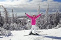 Young woman in pink ski jacket with skis on her feet holding ski Royalty Free Stock Photo