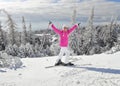 Young woman in pink ski jacket with skis on her feet Royalty Free Stock Photo