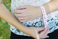 Young woman placing a white bracelet with motivational message stating: I can and I will