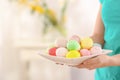 Young woman with plate full of colorful Easter eggs, closeup