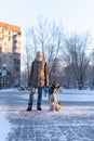 Young woman play with dog walking with snow on Winter. vertical photo Royalty Free Stock Photo