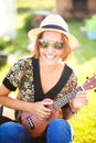 Young woman play on Ukulele.