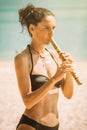 Young woman playing bamboo flute on the beach Royalty Free Stock Photo