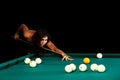 Young woman playing billiard. Black background. Royalty Free Stock Photo