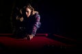 Young woman playing billiards in the dark billiard club Royalty Free Stock Photo