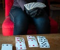 Young woman playing  cards alone at home wearing medical gloves,solitare ,while confined at home Royalty Free Stock Photo