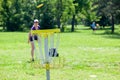 Young woman playing flying disc golf sport game in the park