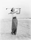 Young woman playing golf at the beach Royalty Free Stock Photo