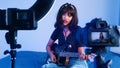 Young woman playing guitar in front of the camera. recording demo or giving online class