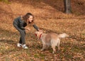 Young woman playing with her dog at the park