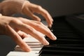 Young woman playing piano against background, closeup Royalty Free Stock Photo