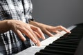 Young woman playing piano against background, closeup Royalty Free Stock Photo