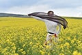 Young woman playing with scarf in a canola field Royalty Free Stock Photo