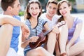 Young woman playing ukulele for friends Royalty Free Stock Photo