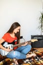 Young woman plays electric guitar at home Royalty Free Stock Photo