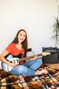 Young woman plays electric guitar at home Royalty Free Stock Photo